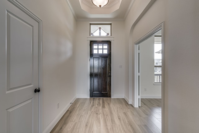 entrance foyer featuring crown molding, light hardwood / wood-style floors, and a raised ceiling