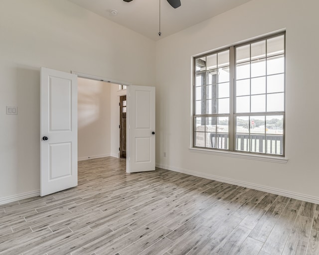 empty room with light wood-type flooring and ceiling fan