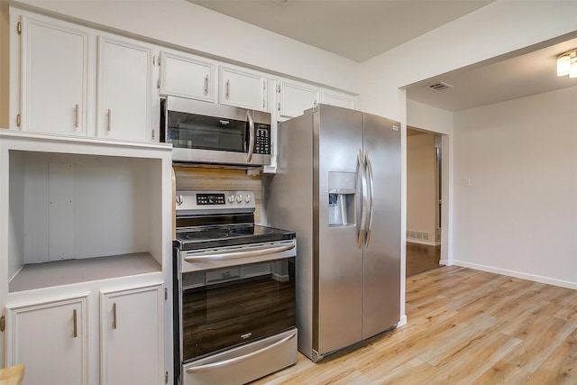 kitchen featuring appliances with stainless steel finishes, light countertops, light wood-style flooring, and white cabinetry