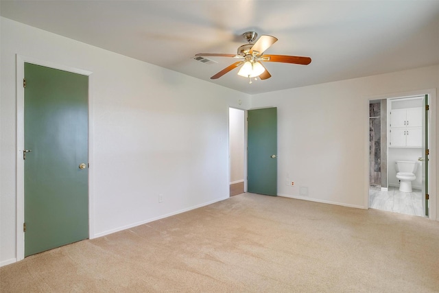 unfurnished bedroom featuring light carpet, visible vents, and ensuite bathroom