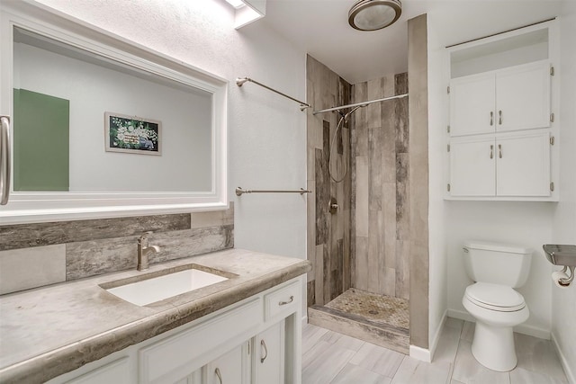 full bathroom featuring tasteful backsplash, toilet, a shower stall, vanity, and baseboards