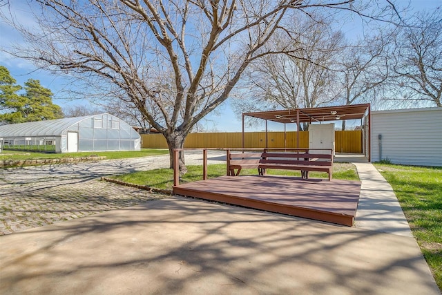 exterior space with a wooden deck, fence, an outdoor structure, and an exterior structure