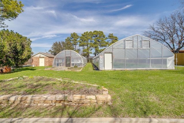 view of yard with an outbuilding and a greenhouse