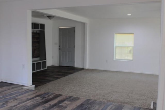 unfurnished room featuring dark colored carpet