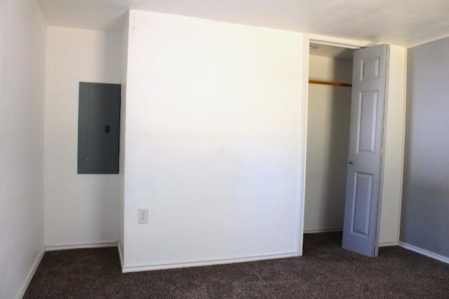 unfurnished bedroom featuring a closet, electric panel, and dark carpet