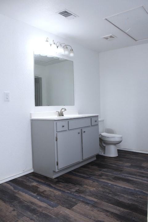 bathroom with hardwood / wood-style floors, toilet, and vanity