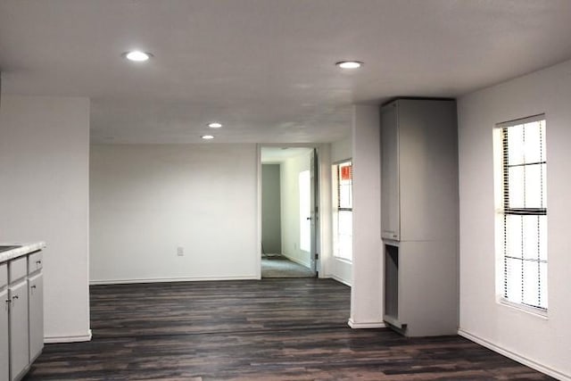 unfurnished room featuring a healthy amount of sunlight and dark hardwood / wood-style flooring