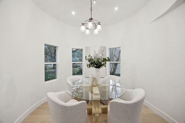 dining room featuring light wood-type flooring and an inviting chandelier