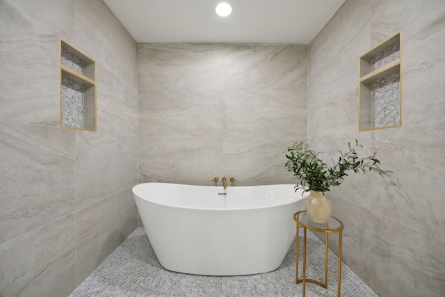 bathroom featuring tile walls and a bathtub