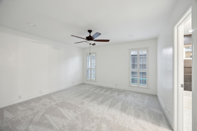 carpeted empty room featuring ceiling fan and plenty of natural light