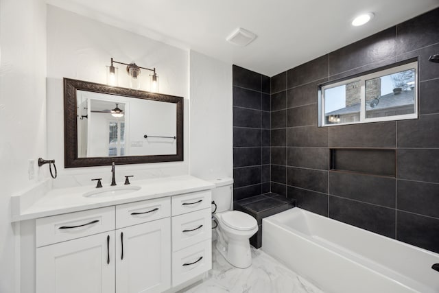 full bathroom featuring toilet, vanity, and tiled shower / bath