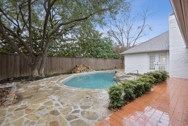 view of swimming pool with french doors and a patio