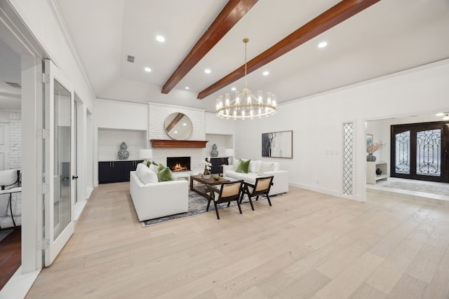 living room featuring a fireplace, beamed ceiling, light hardwood / wood-style floors, and french doors