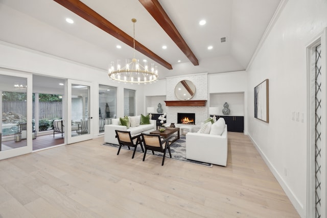 living room featuring beam ceiling, a brick fireplace, a chandelier, and light hardwood / wood-style flooring