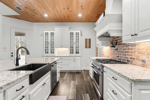 kitchen featuring stainless steel appliances, white cabinets, a sink, and glass insert cabinets