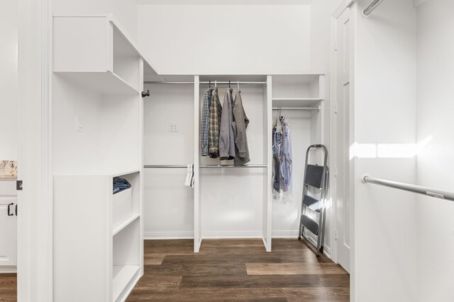 walk in closet with dark wood-style flooring