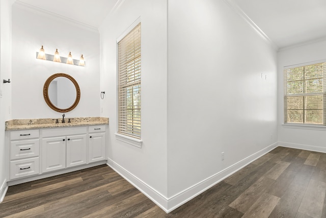 bathroom featuring baseboards, wood finished floors, and crown molding