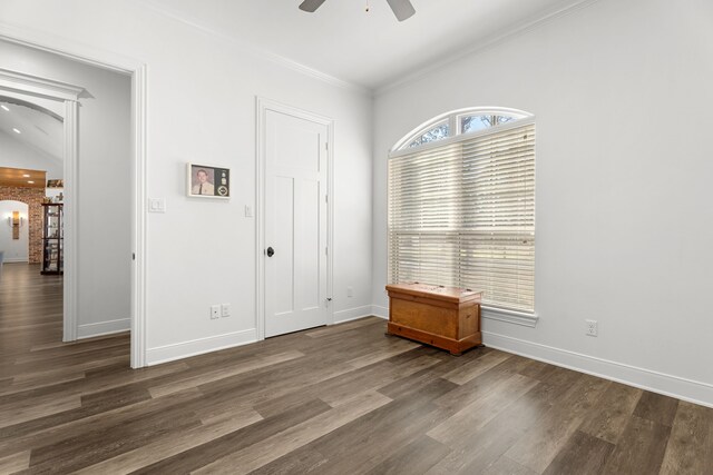 unfurnished room with ceiling fan, dark wood-type flooring, crown molding, and baseboards