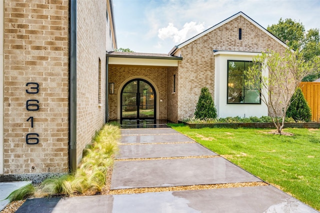 property entrance featuring a yard and french doors