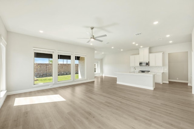 unfurnished living room featuring light wood-style flooring, ceiling fan, baseboards, and recessed lighting