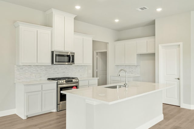 kitchen with visible vents, light wood-type flooring, a sink, and appliances with stainless steel finishes