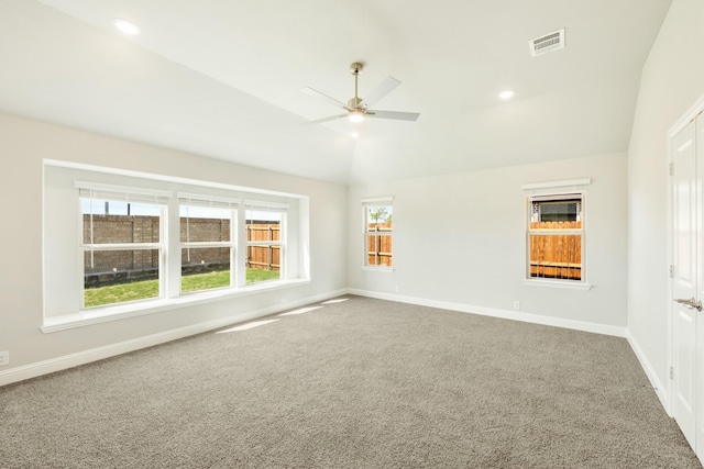carpeted empty room featuring visible vents, baseboards, a ceiling fan, and lofted ceiling