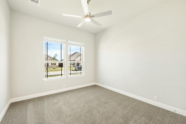 empty room with carpet flooring, visible vents, baseboards, and a ceiling fan