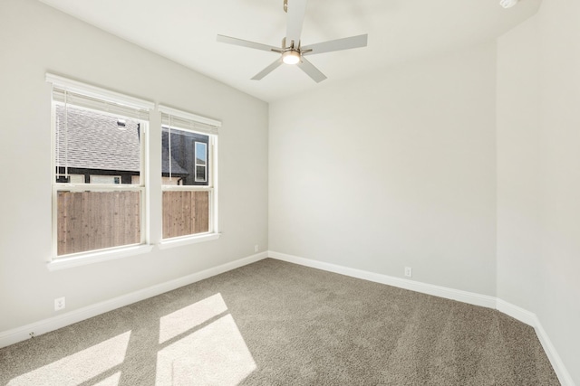 carpeted spare room with baseboards and a ceiling fan