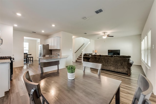 dining room featuring ceiling fan, light hardwood / wood-style flooring, and sink