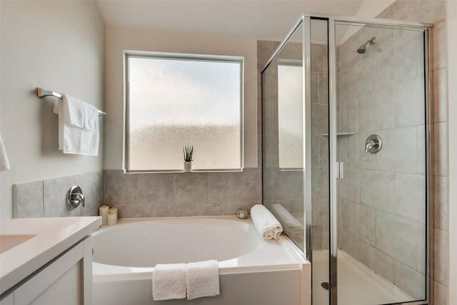 bathroom featuring vanity and independent shower and bath