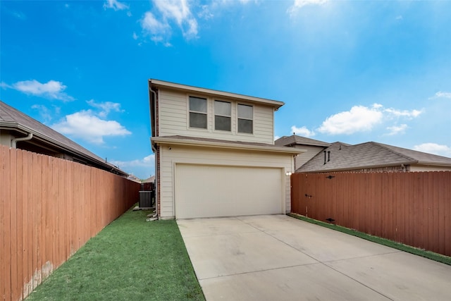 exterior space with a front lawn, central AC unit, and a garage