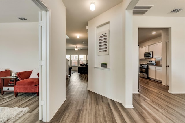 hallway with hardwood / wood-style flooring