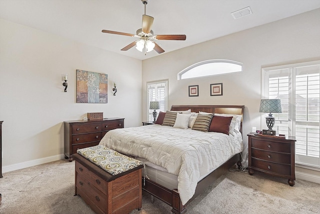 bedroom with light colored carpet, visible vents, and multiple windows