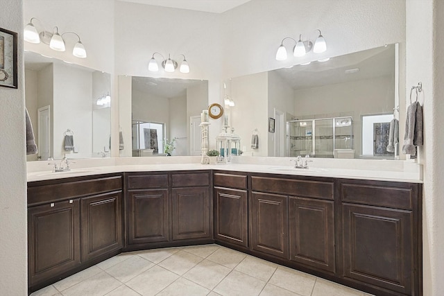 full bathroom with a stall shower, tile patterned flooring, a sink, and double vanity