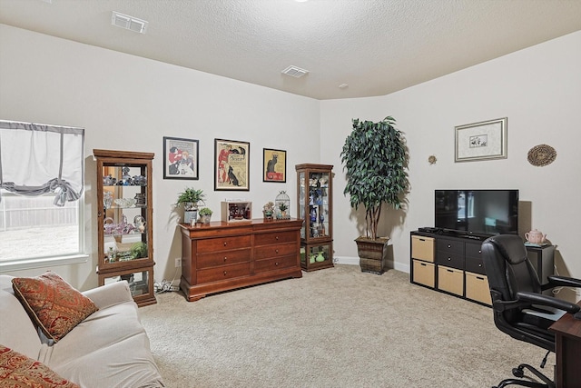 office area featuring baseboards, carpet, visible vents, and a textured ceiling