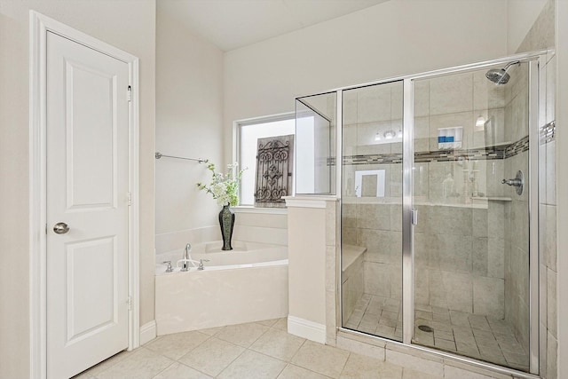 bathroom with a stall shower, tile patterned flooring, and a bath