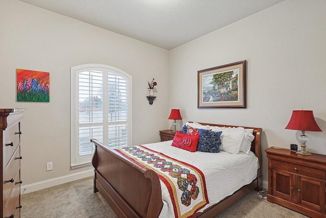 bedroom with baseboards and light colored carpet