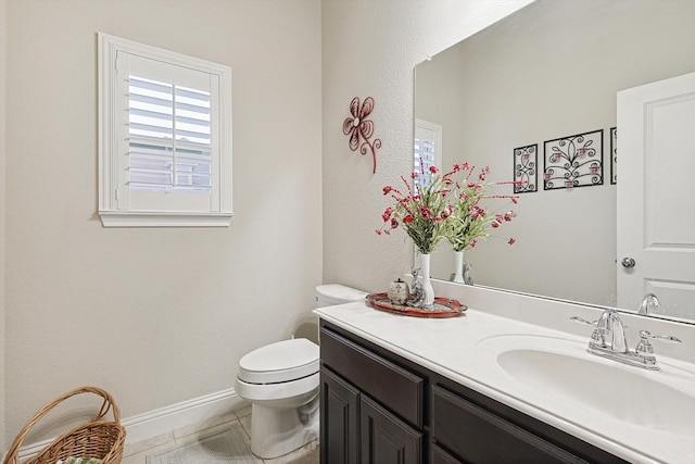 half bath featuring baseboards, vanity, toilet, and tile patterned floors