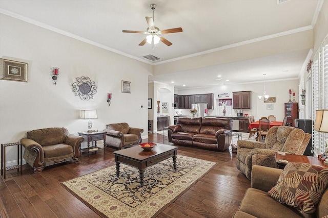 living area with a ceiling fan, dark wood finished floors, visible vents, and crown molding