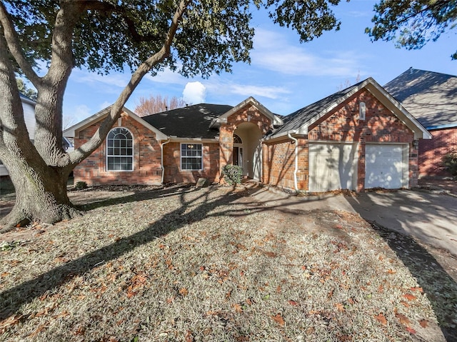 single story home featuring brick siding, driveway, and an attached garage