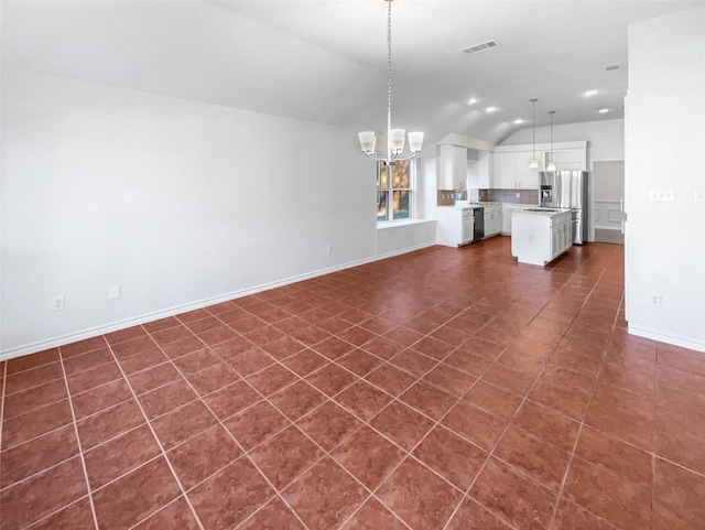 unfurnished living room featuring lofted ceiling, dark tile patterned floors, visible vents, and baseboards