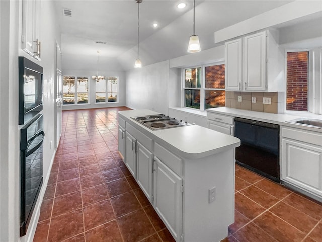 kitchen featuring white cabinets, vaulted ceiling, light countertops, a center island, and black appliances