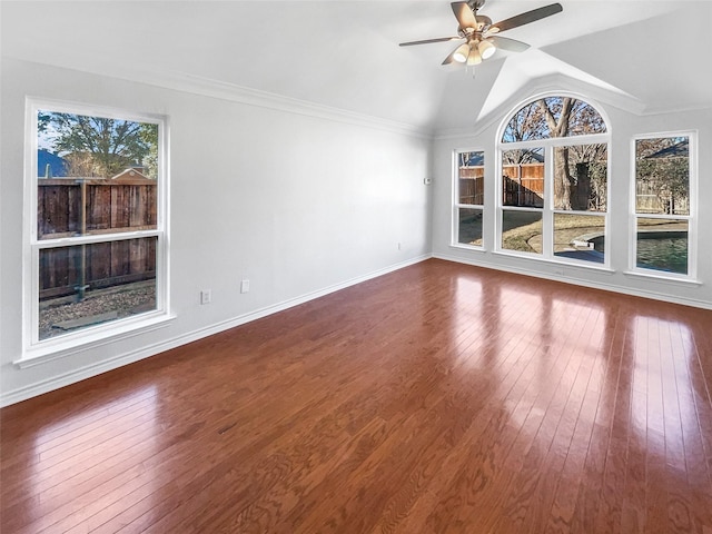 interior space featuring ceiling fan, wood finished floors, baseboards, vaulted ceiling, and ornamental molding