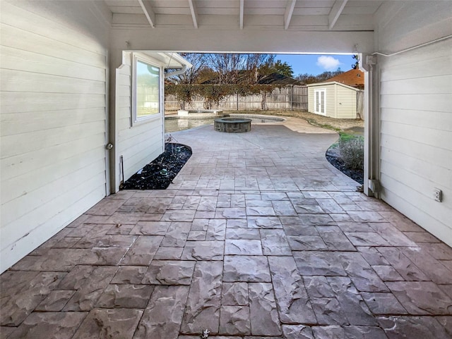 view of patio / terrace featuring a shed, an outdoor structure, a fenced backyard, and an in ground hot tub