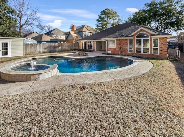 view of swimming pool with a fire pit, fence, a storage unit, and an outbuilding