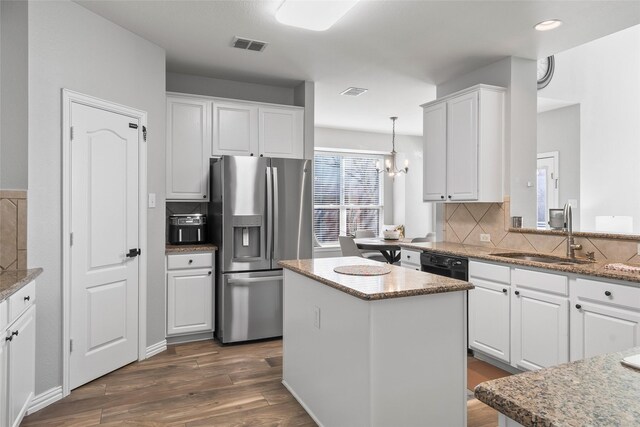 kitchen with stainless steel fridge, white cabinets, dark wood-style floors, a kitchen island, and a sink