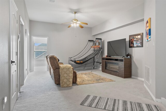 living room featuring light colored carpet, visible vents, a ceiling fan, vaulted ceiling, and baseboards