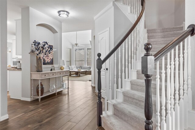 entrance foyer with stairway, baseboards, a ceiling fan, and dark wood-style flooring