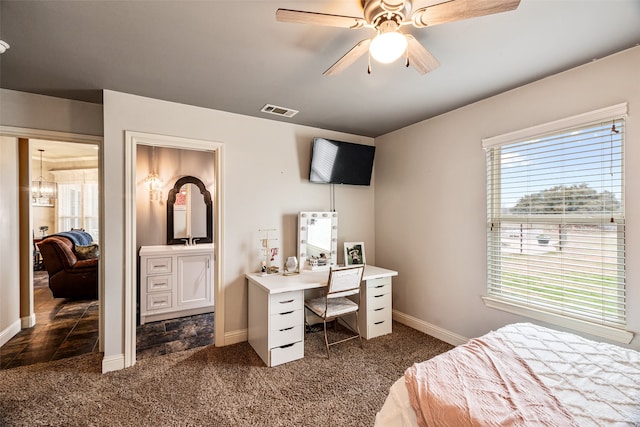 carpeted bedroom featuring ceiling fan with notable chandelier