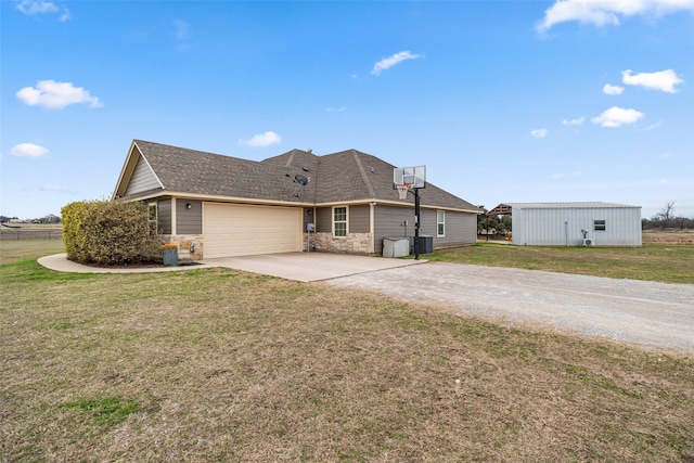 view of front of home featuring central AC, a front yard, and a garage